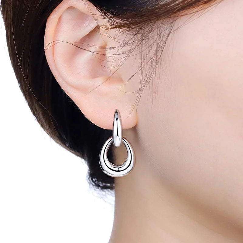 Boucles d'oreilles créoles Adrienne, portées en gros plan sur l'oreille