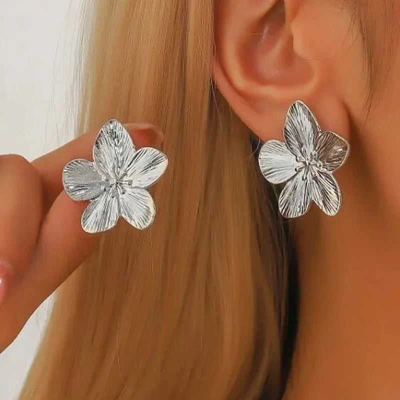 Boucles d'oreilles créoles Marguerite, portées argentées en gros plan sur l'oreille
