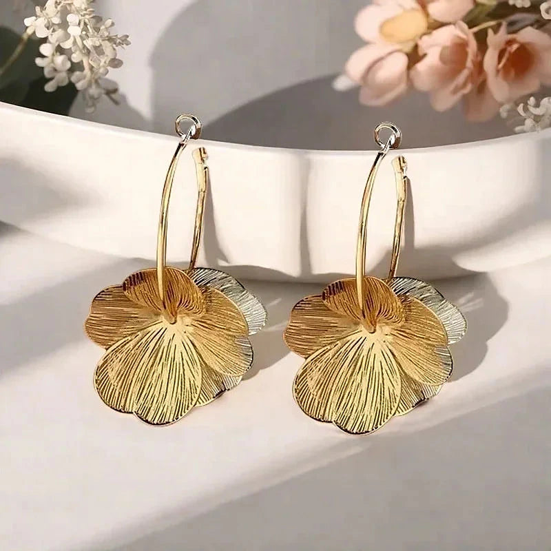 Boucles d'oreilles créoles Marguerite, la paire dorée posée à plat