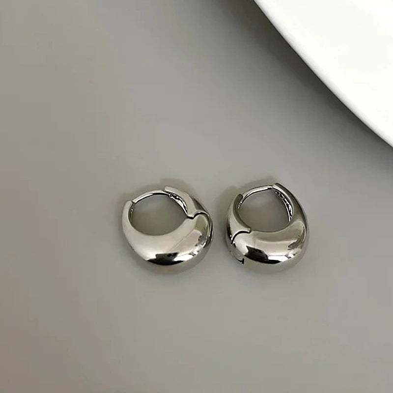 Boucles d'oreilles créoles Vivienne, la paire argentée sur fond clair