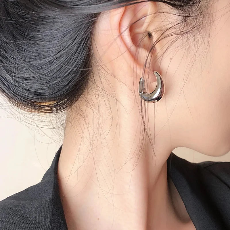 Boucles d'oreilles créoles Vivienne, portée argentée en gros plan sur l'oreille