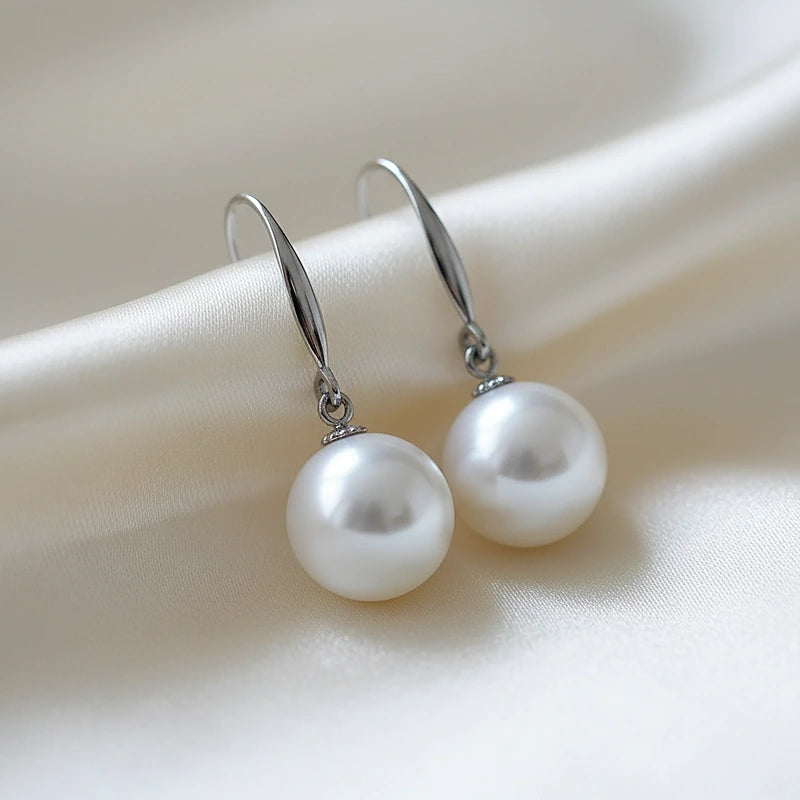 Boucles d'oreilles perles Adèle, posées sur une soie ivoire