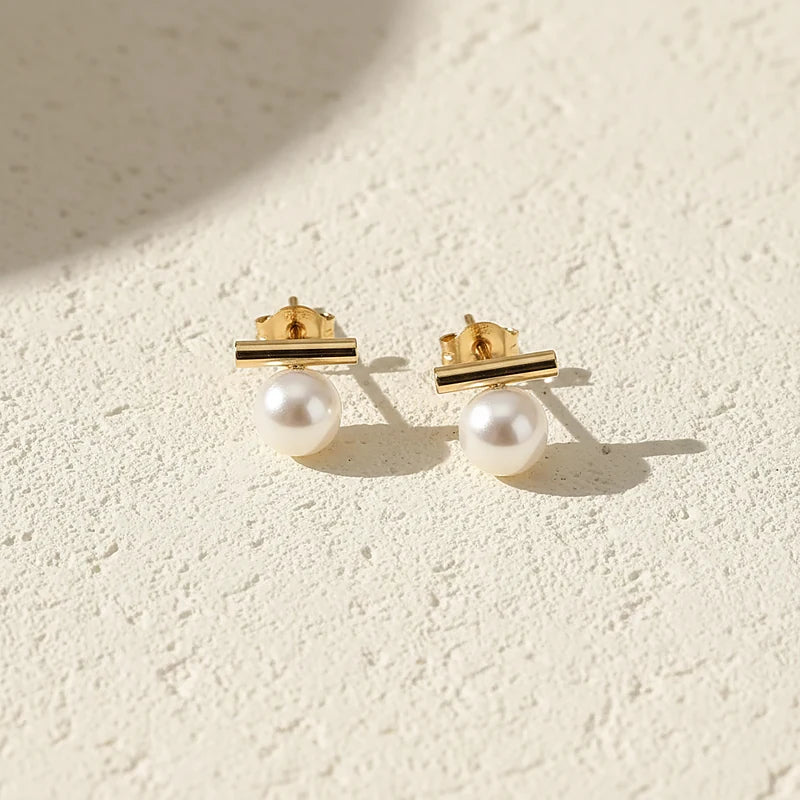 Boucles d'oreilles perles Agathe, posées sur une surface en plâtre crème