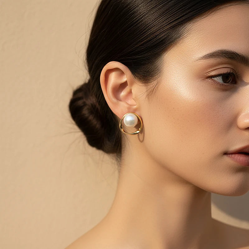Boucles d'oreilles perles et anneau ondulé doré portées, gros plan sur l'oreille