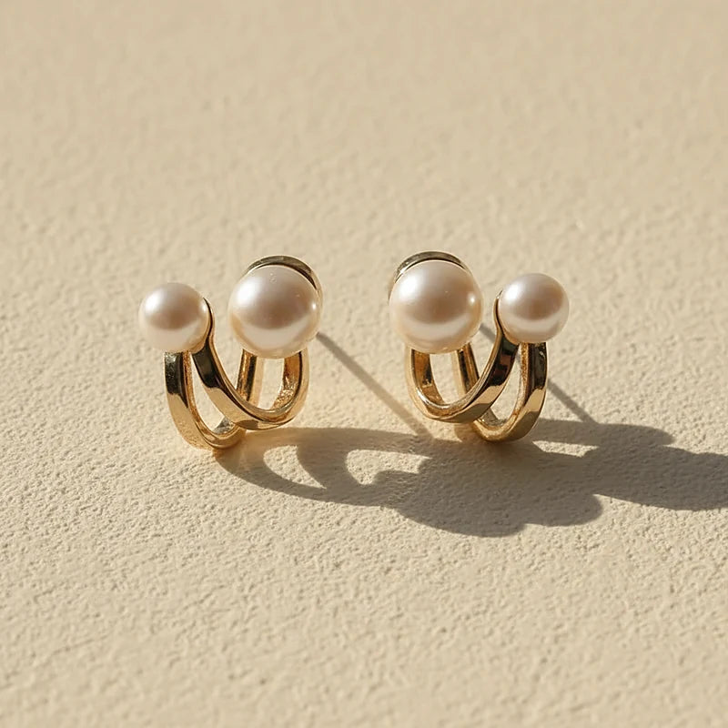 Boucles d'oreilles perles Apolline, posées sur une surface en plâtre crème