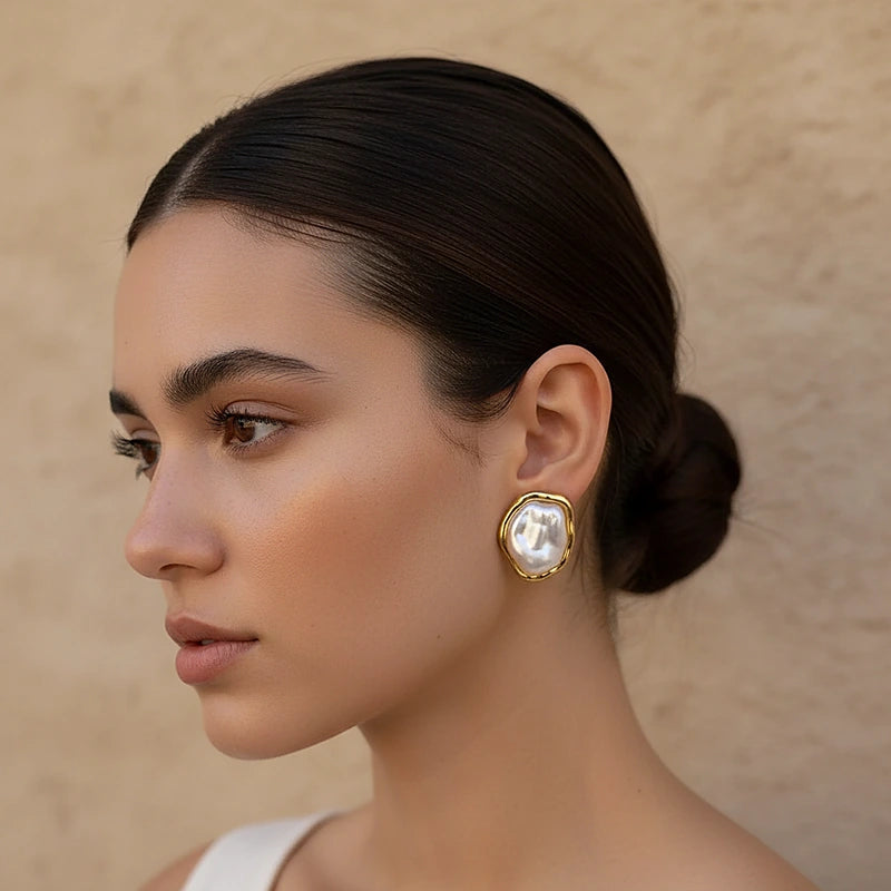 Boucles d'oreilles perles baroques dorées portées, gros plan sur l'oreille