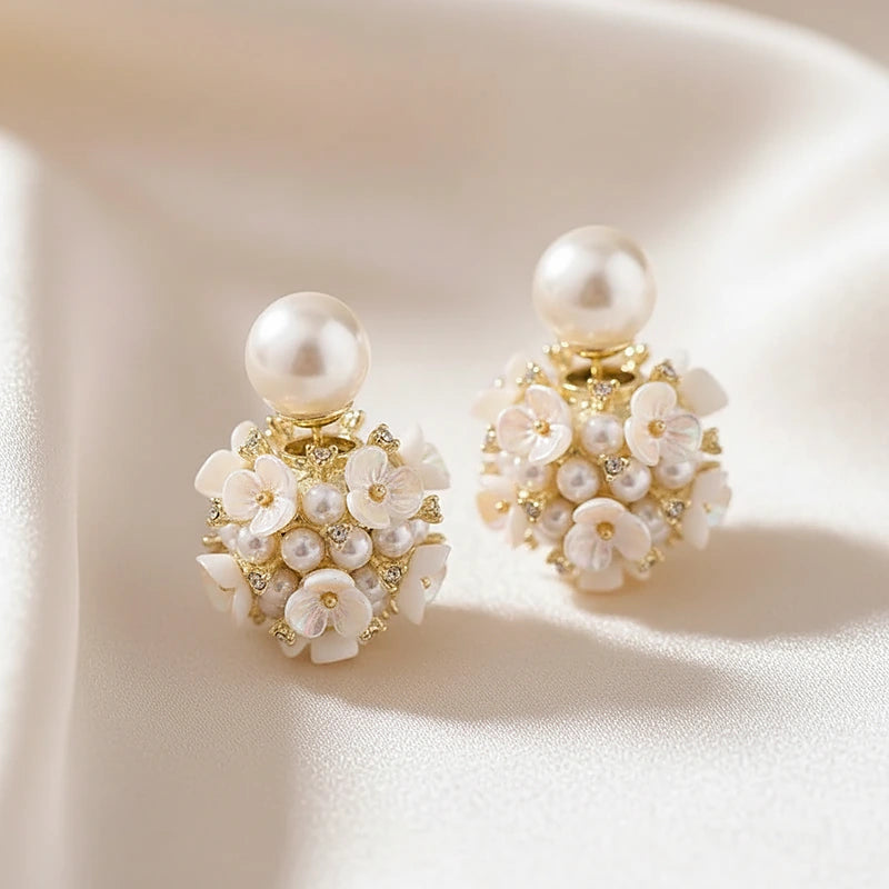 Boucles d'oreilles perles Camélia, posées sur une soie ivoire