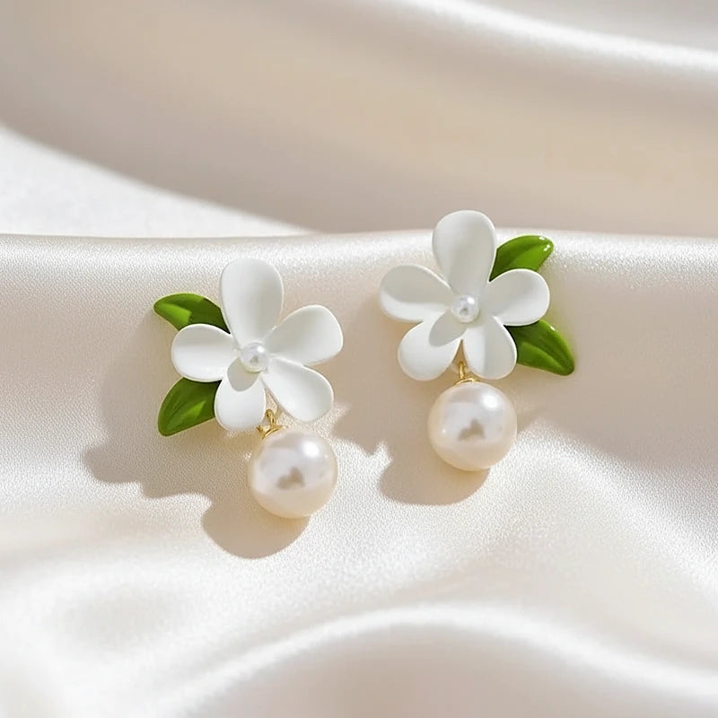 Boucles d'oreilles perles Capucine, posées sur une soie ivoire