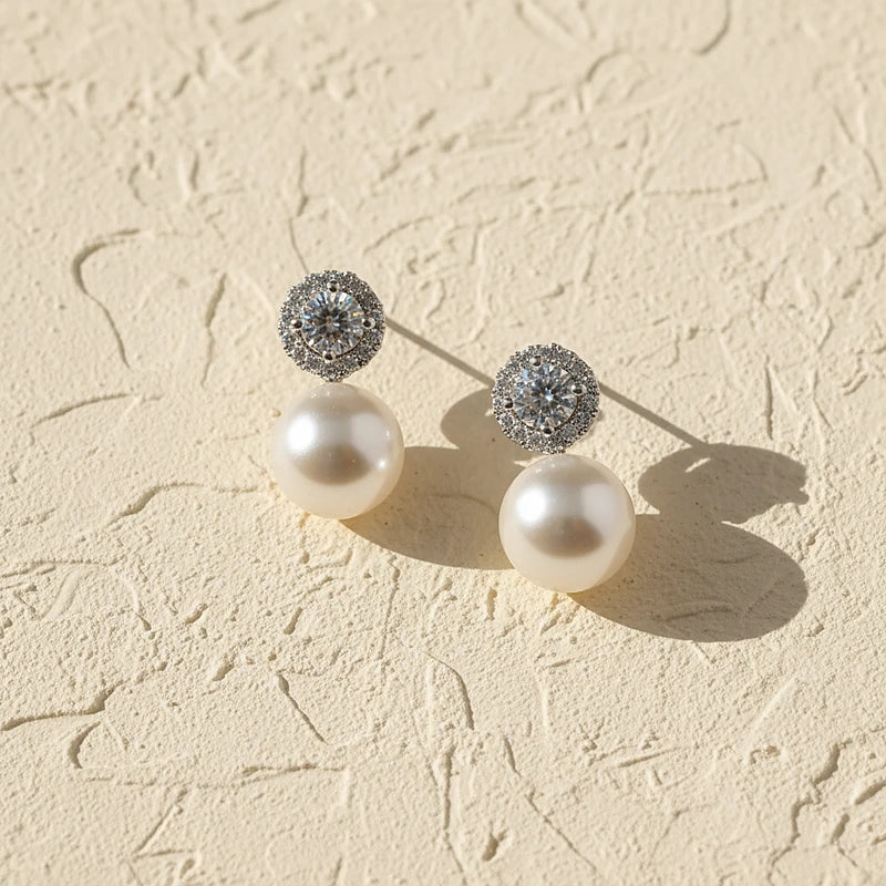 Boucles d'oreilles perles Célestine, posées sur une surface en plâtre crème