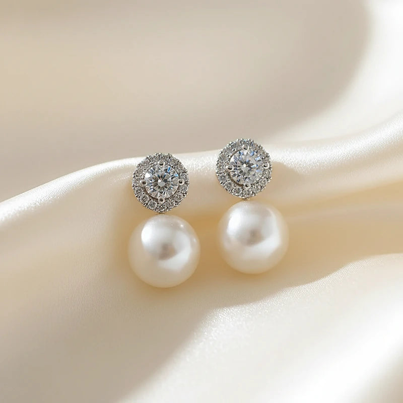 Boucles d'oreilles perles Célestine, posées sur une soie ivoire