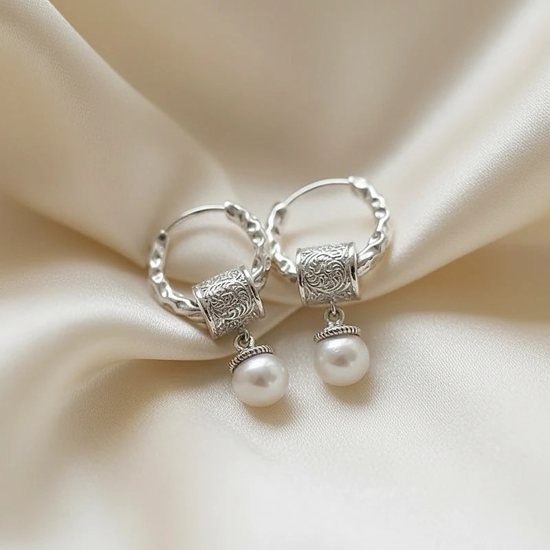 Boucles d'oreilles perles Colette, posées sur une soie ivoire