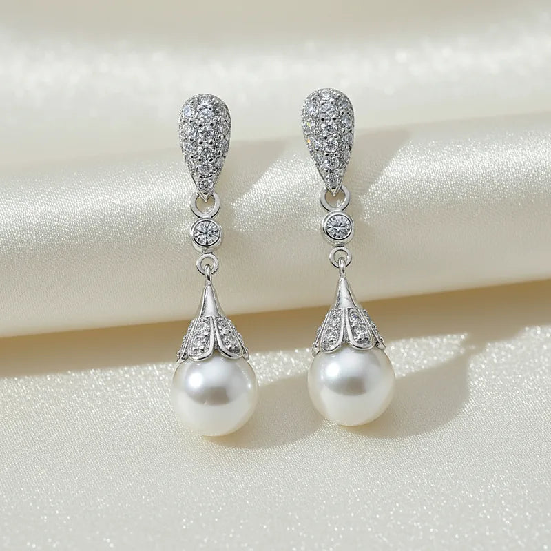 Boucles d'oreilles perles Eugénie, posées sur une soie ivoire