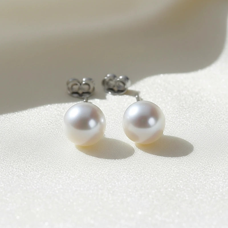 Boucles d'oreilles perles Simone, posées sur une soie ivoire
